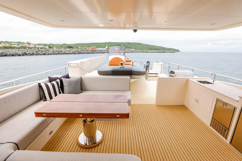 Slide: The Image of Luxurious 2027 Fleming 85 Pilothouse yacht deck with seating, table, and ocean view. - 65