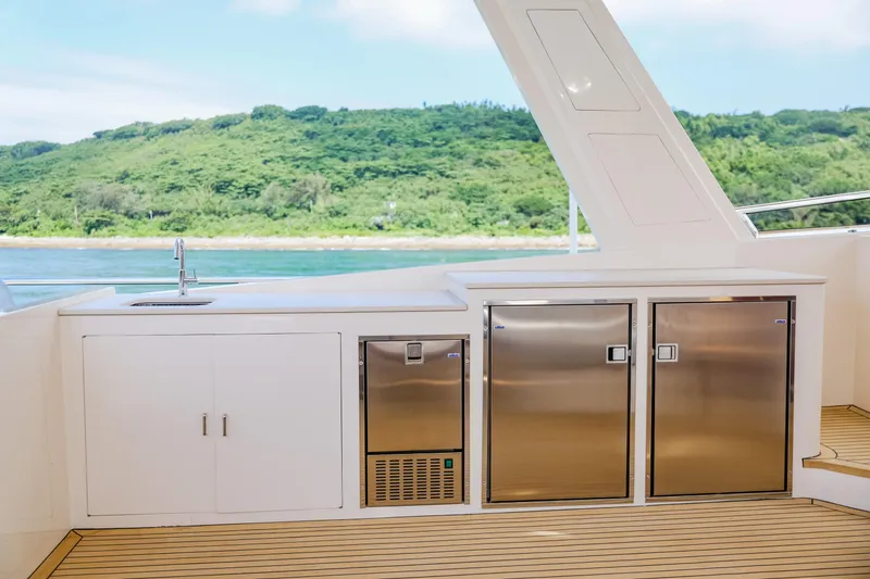 Slide: The Image of Outdoor kitchen on 2027 Fleming 85 Pilothouse yacht with stainless steel appliances and scenic view. - 67