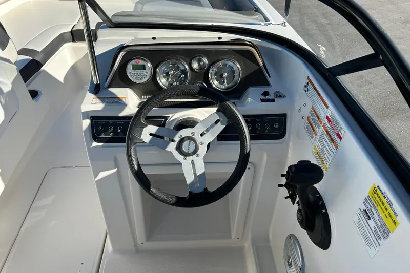 Slide: The Image of 2021 Bayliner DX 2000 boat dashboard with steering wheel and control panel. - 12