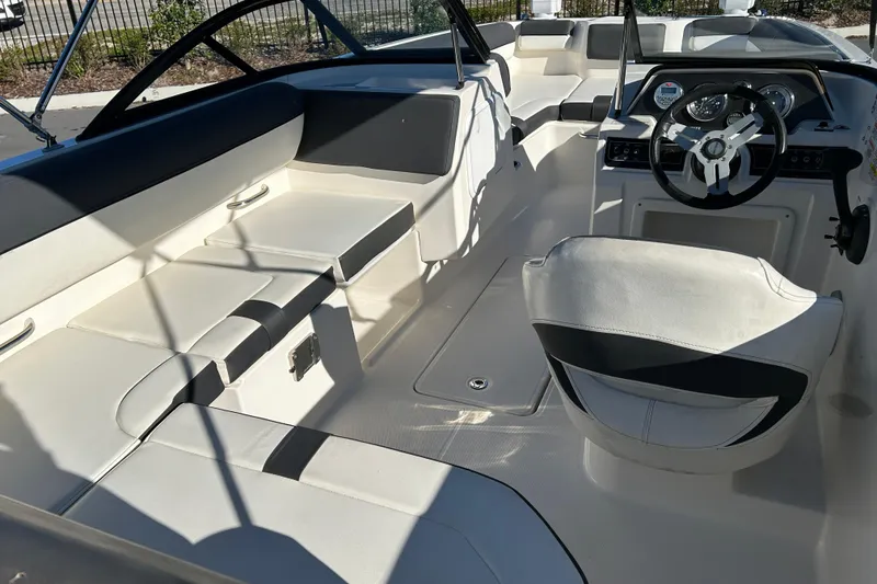 Slide: The Image of 2021 Bayliner DX 2000 boat interior with seating and steering wheel. - 13