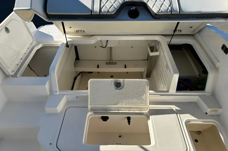 Slide: The Image of 2021 Bayliner DX 2000 boat storage compartments with open hatches and seating. - 18