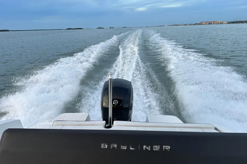 Slide: The Image of Bayliner DX 2000 boat cruising on open water, leaving a wake trail. - 20