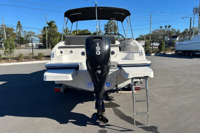 Slide: The Image of 2021 Bayliner DX 2000 boat with outboard motor and swim platform in a sunny marina. - 3