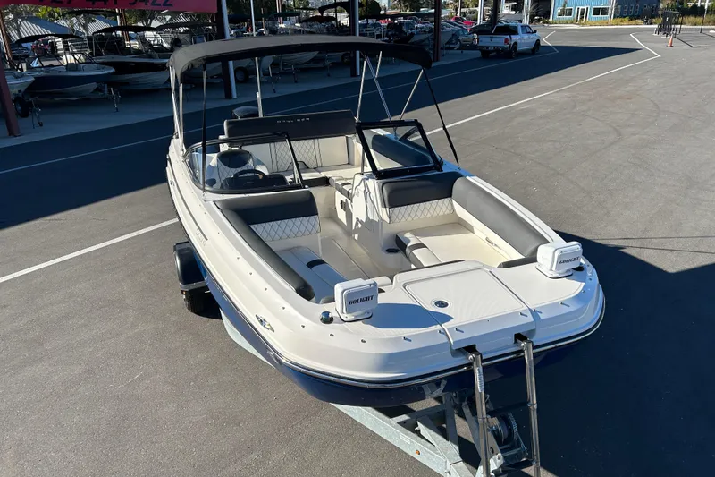 Slide: The Image of 2021 Bayliner DX 2000 boat on trailer, parked in a marina lot. - 6