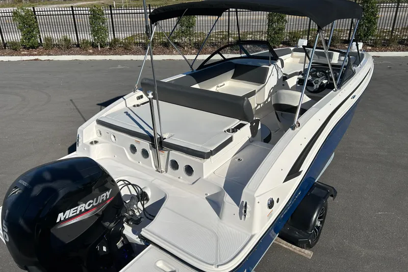 Slide: The Image of 2021 Bayliner DX 2000 boat with Mercury engine, featuring spacious seating and canopy. - 7