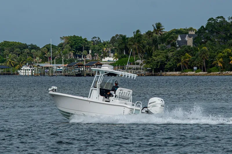 Slide: The Image of 2022 Blazer Bay 2700 Hybrid boat cruising on a scenic waterway with lush greenery. - 14