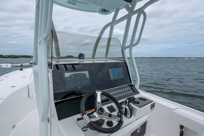 Slide: The Image of 2022 Blazer Bay 2700 Hybrid boat dashboard with steering wheel and navigation screens. - 3