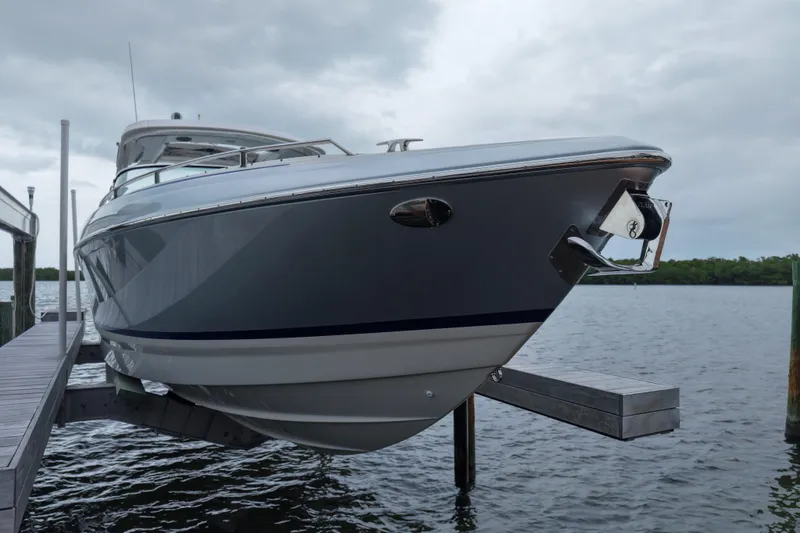 Slide: The Image of 2018 Formula 350 FX Crossover Bowrider on lift by dock, overcast sky. - 14