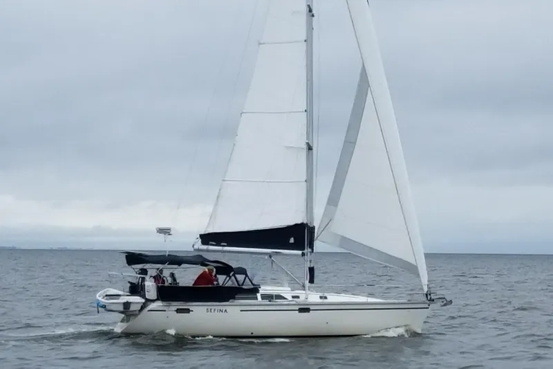The Image of 1991 Hunter Legend 37.5 sailboat cruising on open water under cloudy skies. - 0