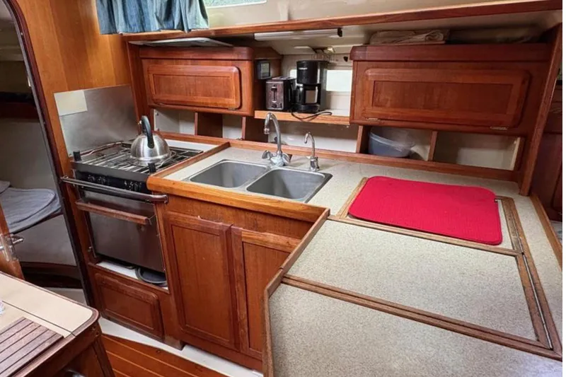 Slide: The Image of 1991 Hunter Legend 37.5 yacht kitchen with wooden cabinets, stove, and dual sink. - 17