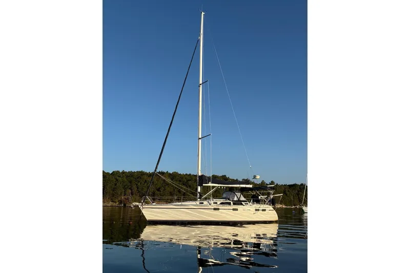 Slide: The Image of 1991 Hunter Legend 37.5 sailboat on calm water, clear blue sky background. - 2