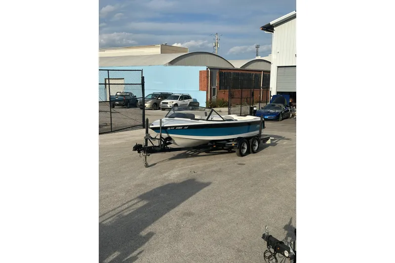 The Image of 1992 Correct Craft Ski Nautique boat on trailer in industrial area. - 1