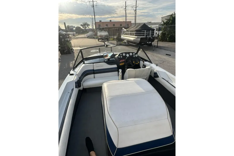 Slide: The Image of 1992 Correct Craft Ski Nautique boat interior with dashboard and seating, parked outdoors. - 15