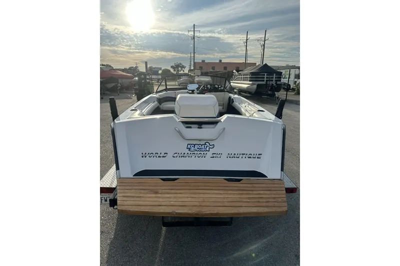 Slide: The Image of 1992 Correct Craft Ski Nautique boat, rear view, parked outdoors under a cloudy sky. - 5