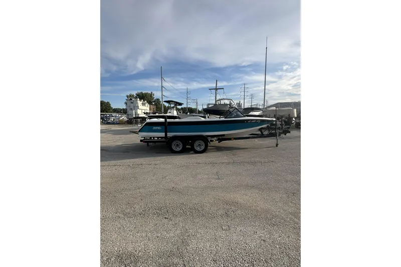 Slide: The Image of 1992 Correct Craft Ski Nautique boat on trailer in parking lot under blue sky. - 7