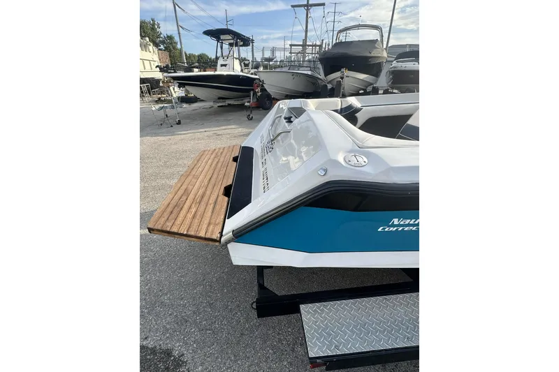 Slide: The Image of 1992 Correct Craft Ski Nautique boat on trailer, docked among other boats. - 9