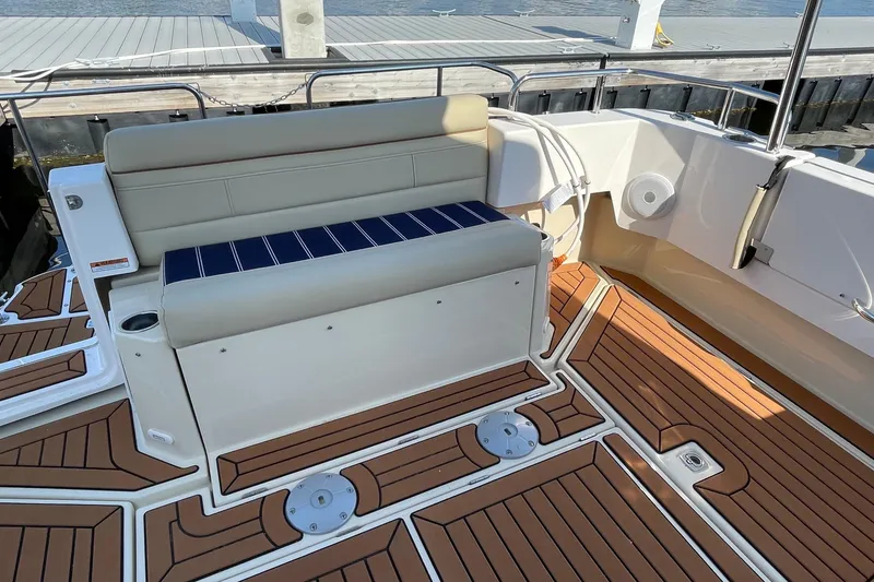Slide: The Image of 2025 Ranger Tugs R-31 S boat deck with cushioned seating and wood-patterned flooring. - 10
