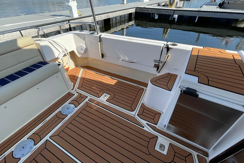 Slide: The Image of 2025 Ranger Tugs R-31 S boat deck with wood finish, docked at marina. - 11