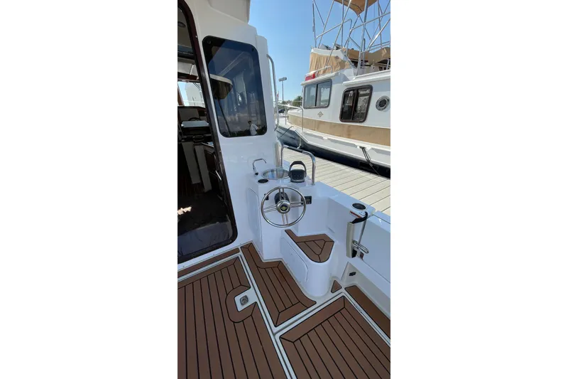 Slide: The Image of 2025 Ranger Tugs R-31 S boat helm with wooden deck and modern controls. - 14