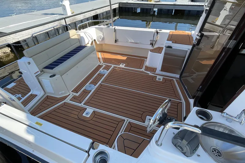 Slide: The Image of 2025 Ranger Tugs R-31 S boat deck with seating and wood-style flooring. - 16