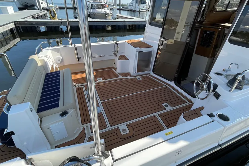 Slide: The Image of 2025 Ranger Tugs R-31 S boat interior with teak flooring and seating area. - 17