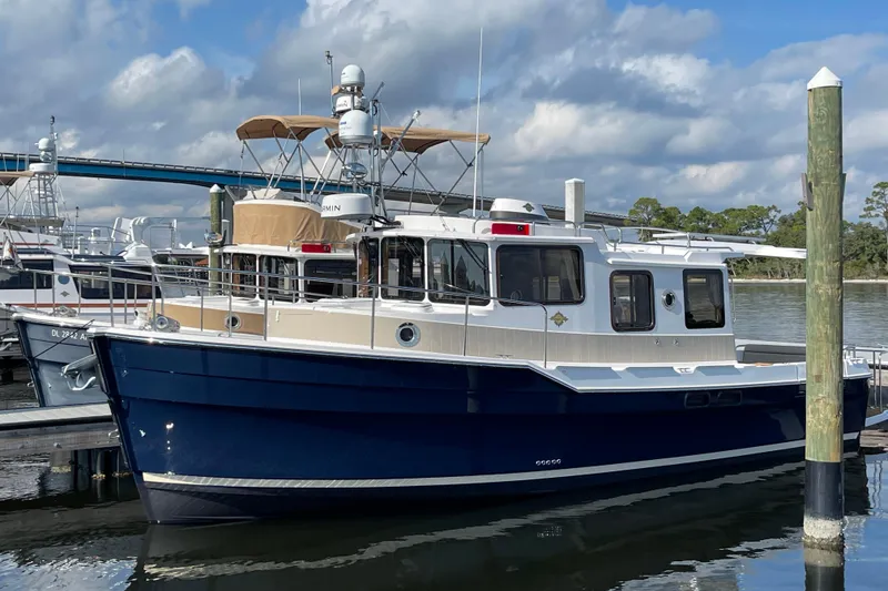 Slide: The Image of 2025 Ranger Tugs R-31 S boat docked at marina under cloudy sky. - 2