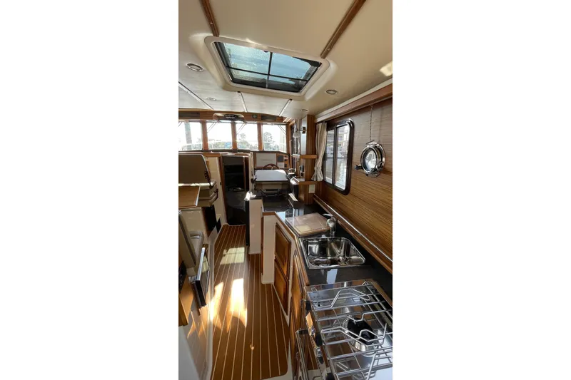 Slide: The Image of Interior of 2025 Ranger Tugs R-31 S, featuring modern kitchen and seating area. - 23