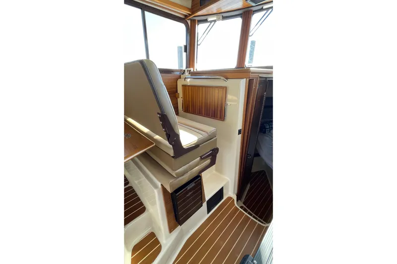 Slide: The Image of Interior of 2025 Ranger Tugs R-31 S, featuring wood accents and seating. - 27