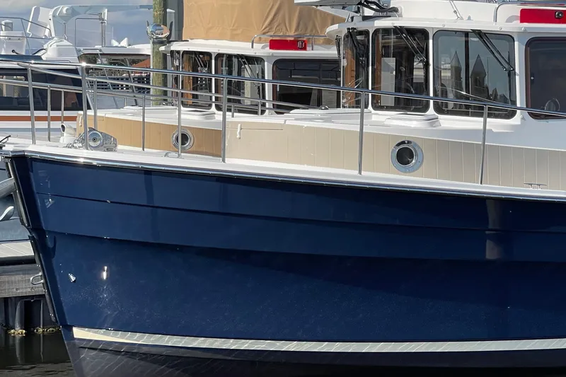 Slide: The Image of 2025 Ranger Tugs R-31 S boat docked, showcasing sleek blue hull and modern design. - 3