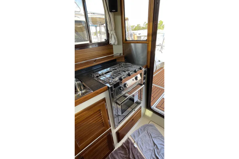 Slide: The Image of Interior of 2025 Ranger Tugs R-31 S with stove and wooden cabinetry. - 30