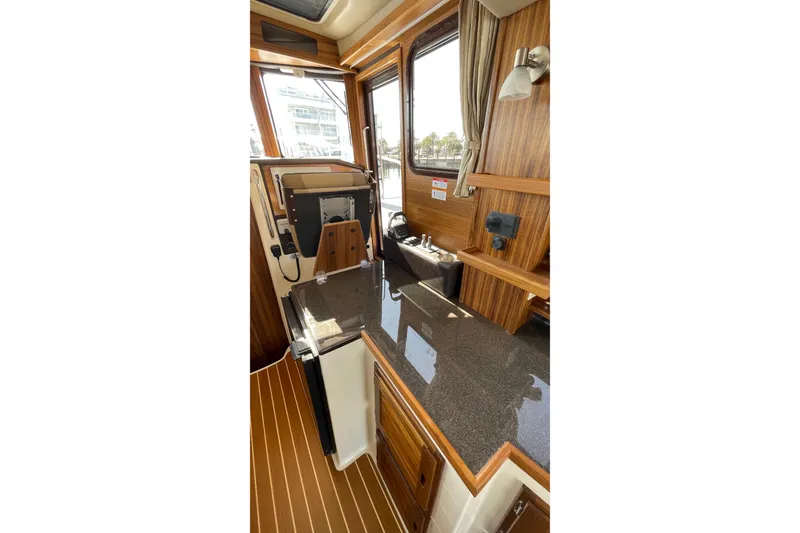 Slide: The Image of 2025 Ranger Tugs R-31 S interior with wood accents and modern amenities. - 34