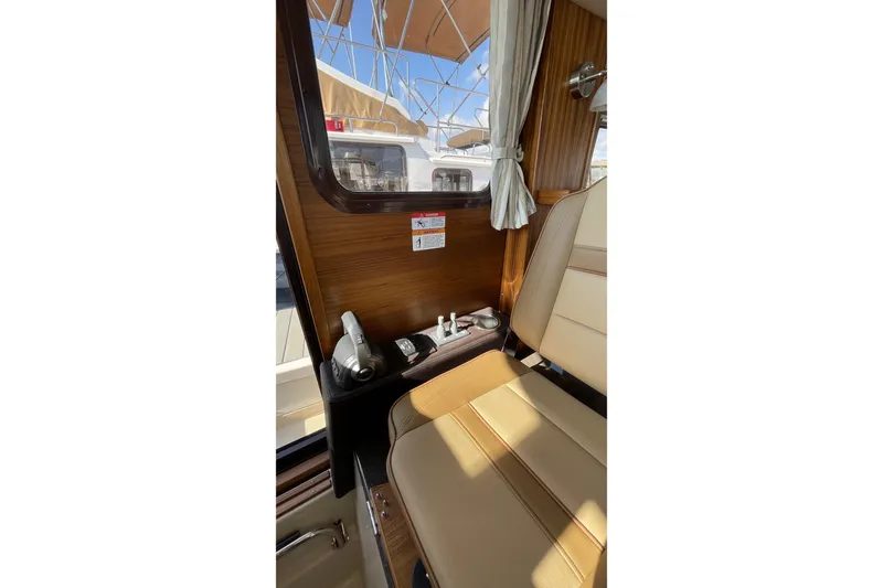 Slide: The Image of Interior of 2025 Ranger Tugs R-31 S, featuring helm controls and seating. - 35