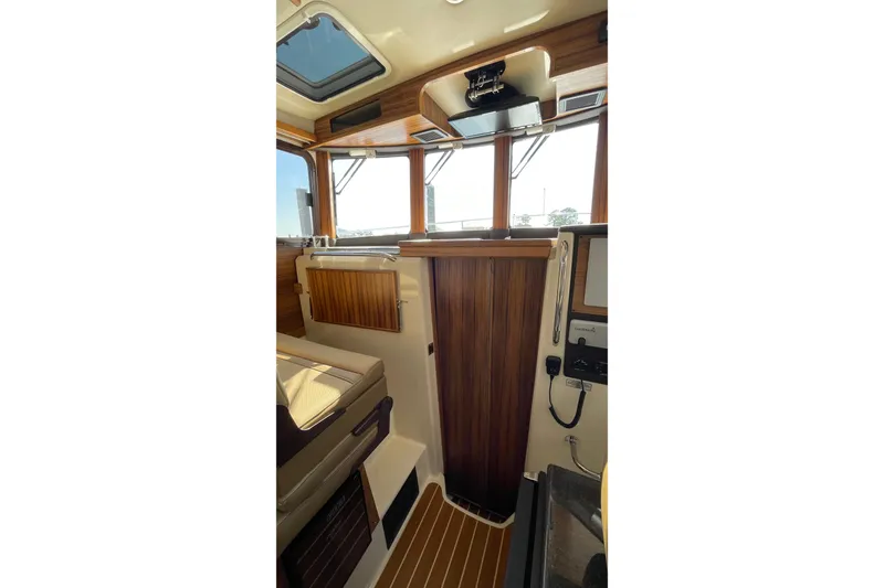 Slide: The Image of Interior of 2025 Ranger Tugs R-31 S, featuring wood paneling and modern controls. - 38