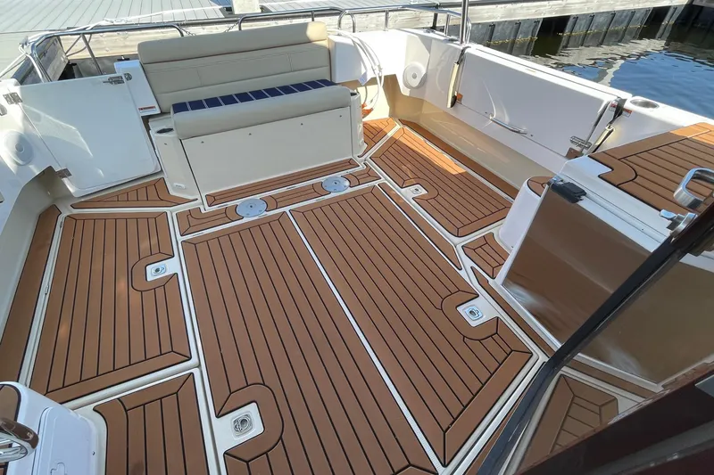 Slide: The Image of 2025 Ranger Tugs R-31 S boat deck with teak-style flooring and seating area. - 9