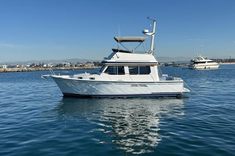 The Image of 2000 Sabre 34 Flybridge boat on calm water, clear sky background. - 0