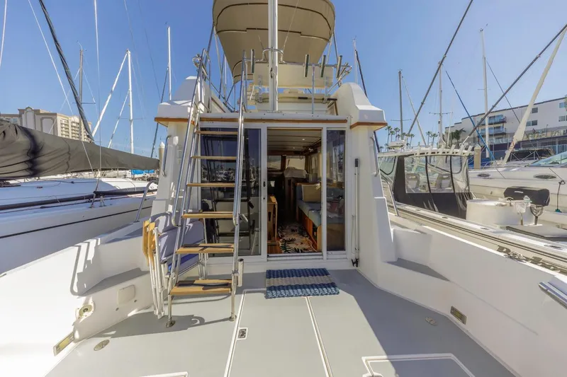 Slide: The Image of 2000 Sabre 34 Flybridge yacht with open deck, ladder, and marina view. - 10