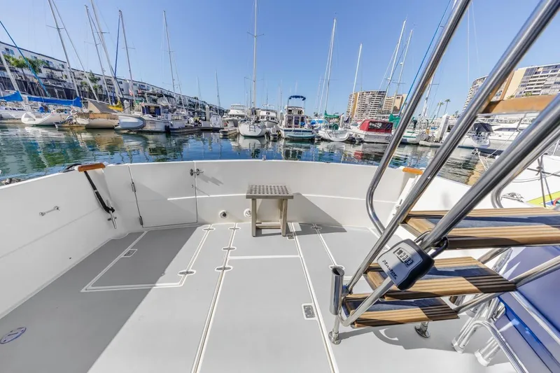 Slide: The Image of Sabre 34 Flybridge 2000 yacht deck with marina view, featuring stainless steel stairs. - 12