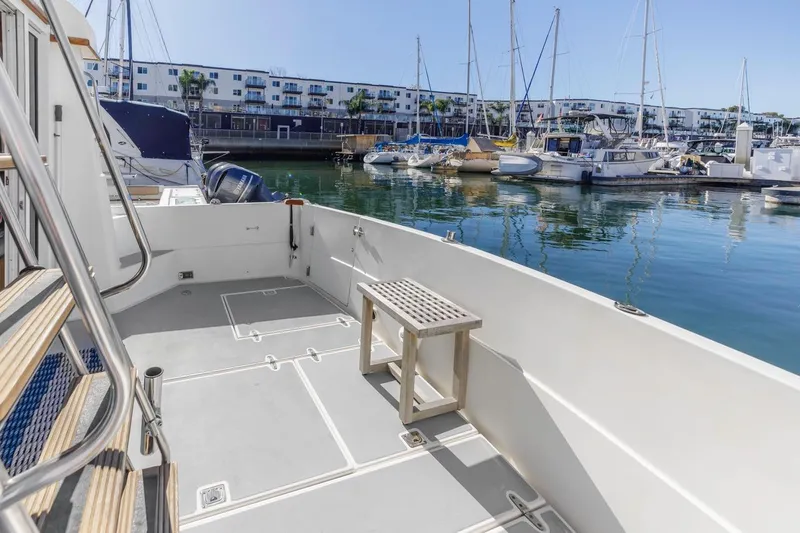 Slide: The Image of 2000 Sabre 34 Flybridge yacht docked in a marina, featuring spacious deck and serene water views. - 13
