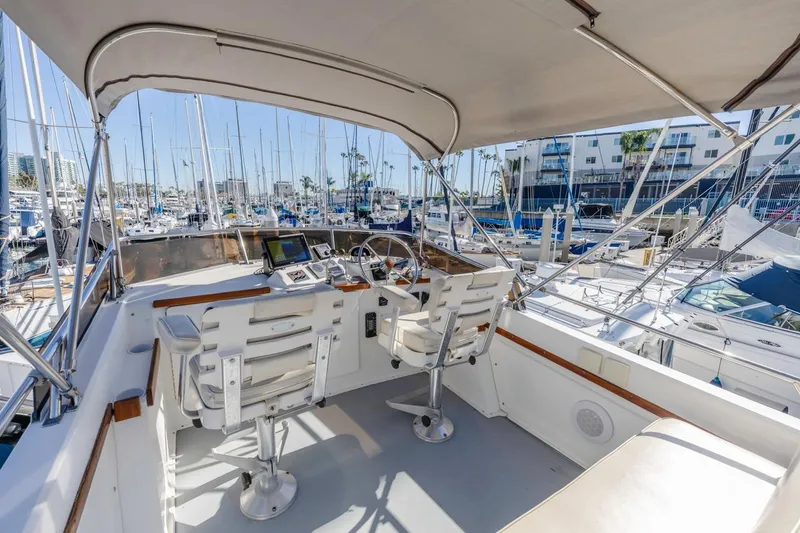 Slide: The Image of Flybridge of 2000 Sabre 34, featuring dual seats and marina view. - 14