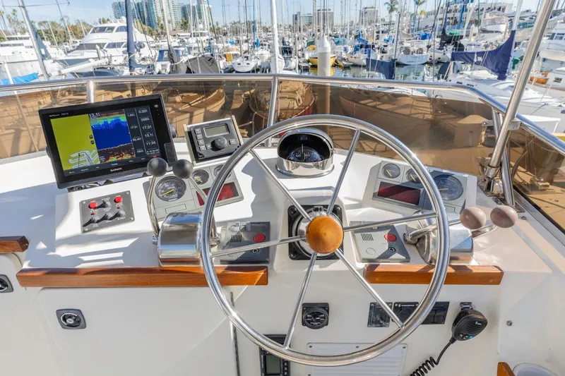 Slide: The Image of Helm of 2000 Sabre 34 Flybridge with navigation equipment and marina view. - 17