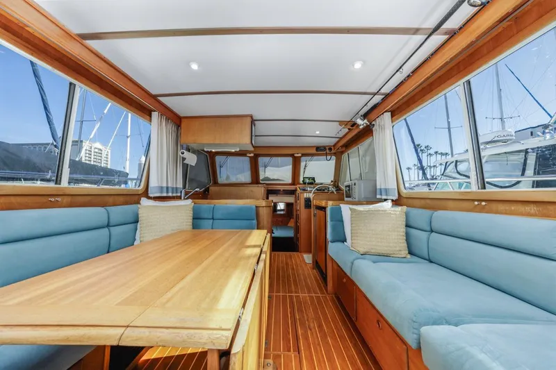 Slide: The Image of Interior of 2000 Sabre 34 Flybridge yacht with wooden table and blue seating. - 22