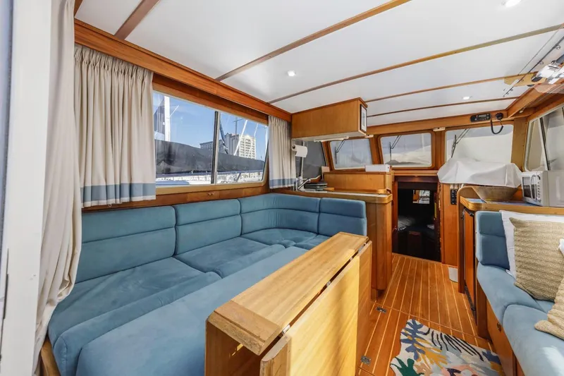 Slide: The Image of Interior of 2000 Sabre 34 Flybridge yacht with blue seating and wooden accents. - 23