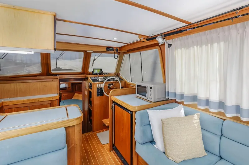 Slide: The Image of Interior of 2000 Sabre 34 Flybridge yacht with wood accents and blue seating. - 25