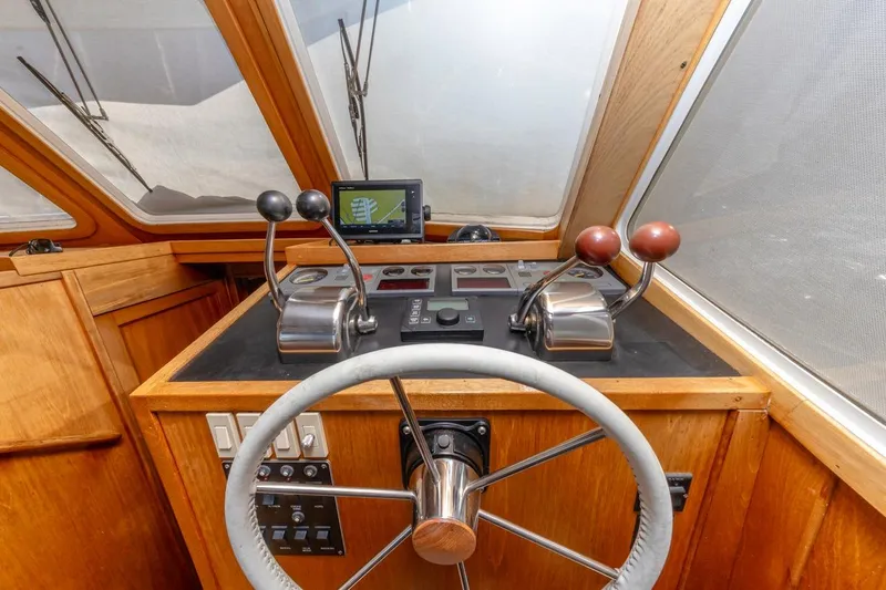 Slide: The Image of Helm of 2000 Sabre 34 Flybridge with steering wheel and control levers. - 27