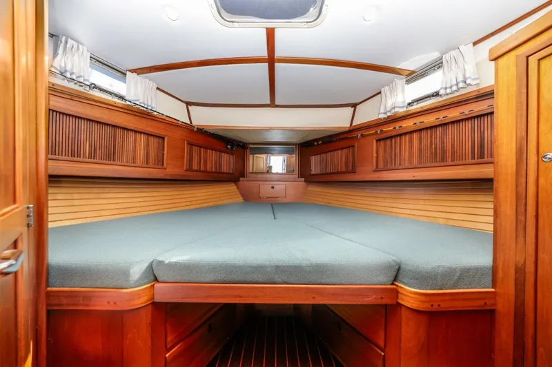 Slide: The Image of Interior cabin of 2000 Sabre 34 Flybridge with wooden finish and cozy bedding. - 34