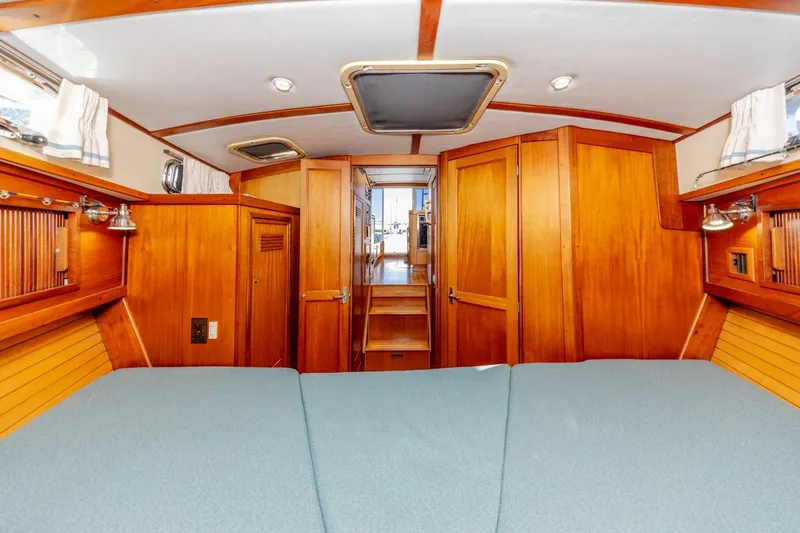 Slide: The Image of Interior of 2000 Sabre 34 Flybridge yacht with wooden cabinetry and blue bedding. - 35