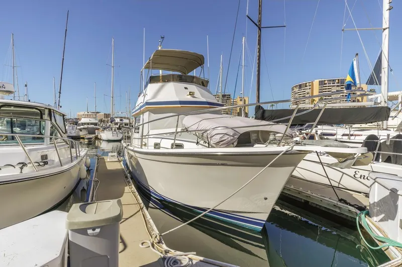 Slide: The Image of 2000 Sabre 34 Flybridge yacht docked in a marina under clear blue skies. - 8
