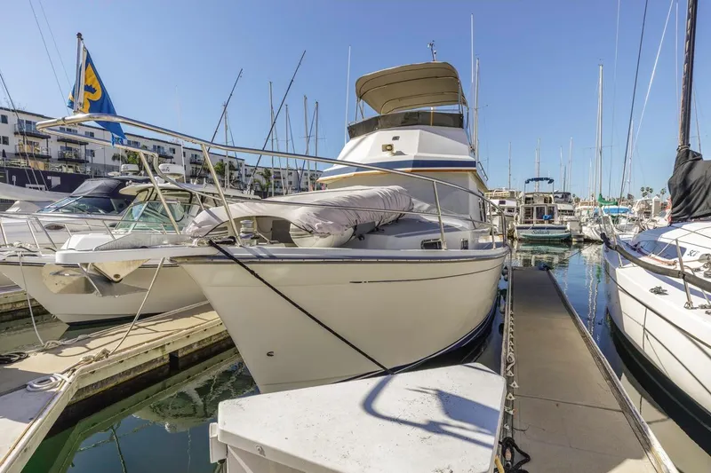 Slide: The Image of 2000 Sabre 34 Flybridge yacht docked at marina under clear blue sky. - 9