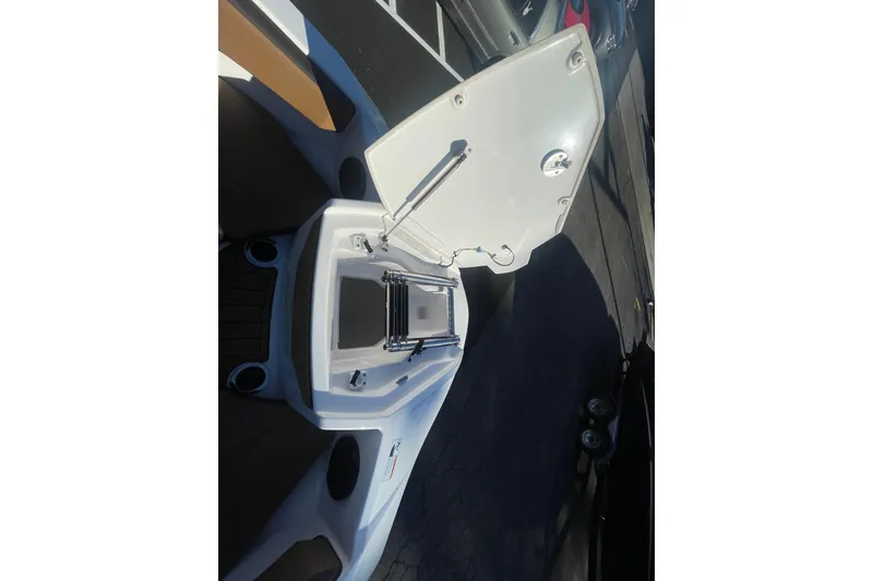 Slide: The Image of 2025 Yamaha Boats 222SD open storage compartment with ladder on deck. - 16