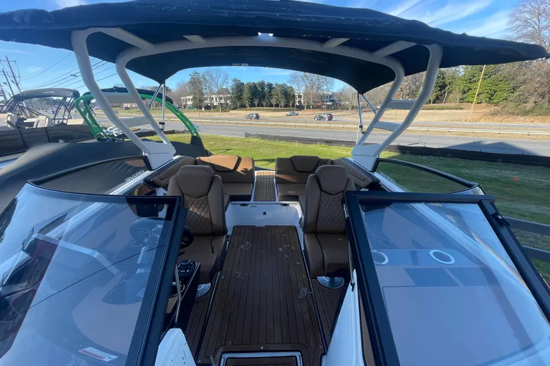 Slide: The Image of 2025 Yamaha Boats 222SD interior with brown seating, open deck, and canopy. - 5